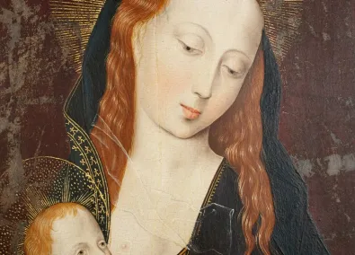 Primer pla d’una pintura religiosa antiga: la Mare de Déu, de pell clara i cabells rogencs, inclina suaument el cap amb expressió serena mentre sosté l’Infant Jesús. Tots dos tenen halos daurats; el fons és fosc i desgastat, amb signes d’envelliment de l’obra.